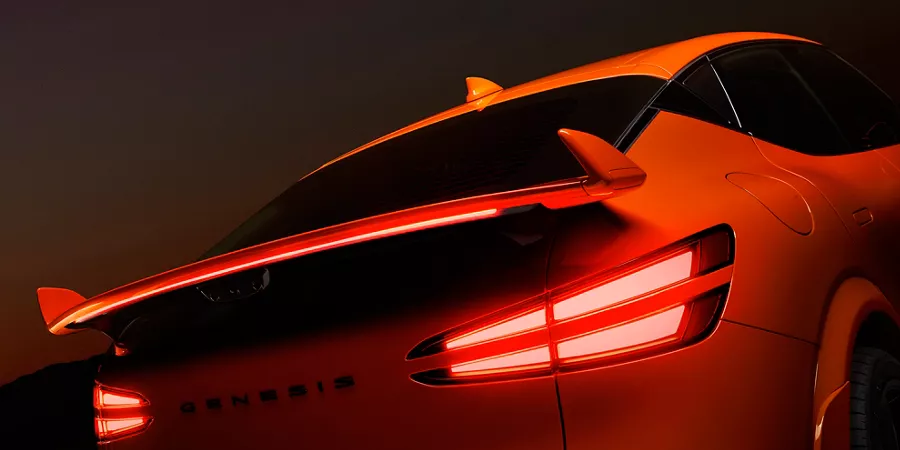 3/4 rear passenger side close up of spoiler and taillights on 2027 Genesis GV60 Magma in orange