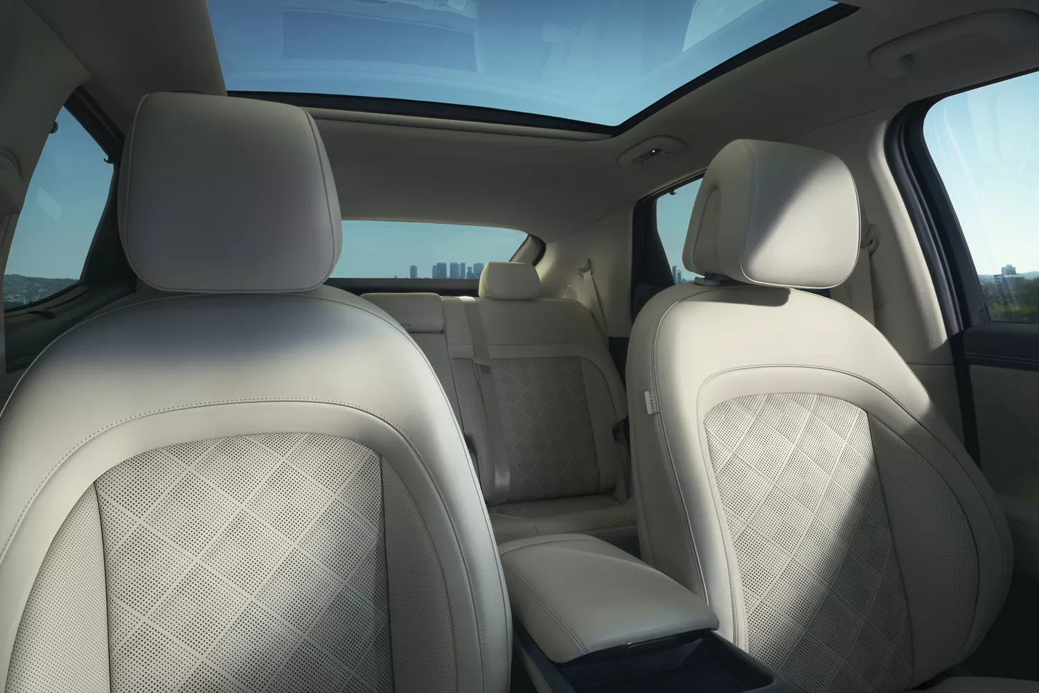 Interior view from dashboard of front and rear Ash Gray, Glacier White seating, inside Genesis GV60