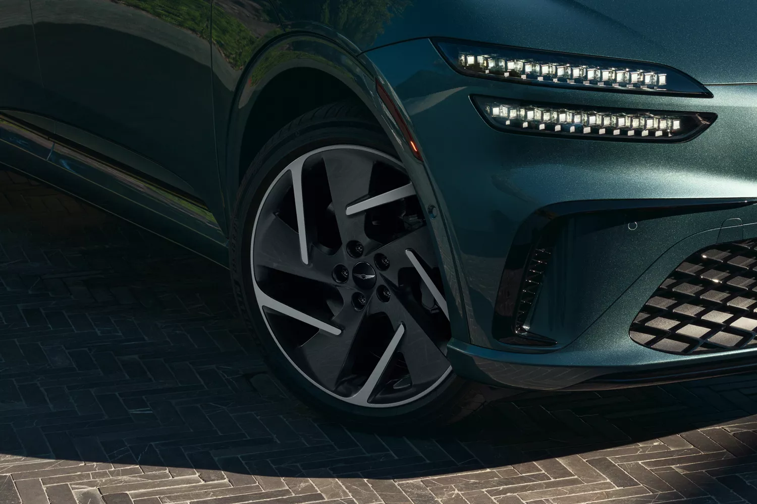 Close up of front passenger side wheel details on Genesis GV60 in Tromso Green