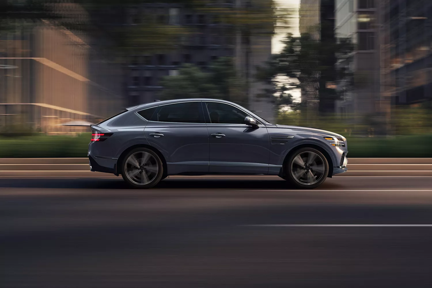 Passenger side profile view of Genesis GV80 Coupe in Ceres Blue driving on a city street