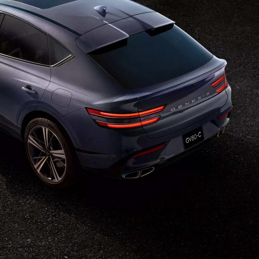 Aerial 3/4 rear driver side view of Genesis GV80 Coupe in Ceres Blue
