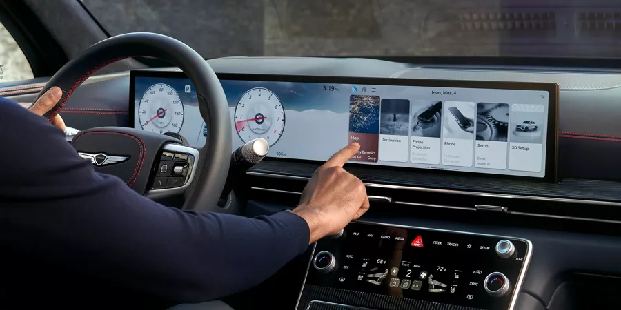 Interior image of driver touching the Navigation Integrated display inside Genesis GV80 Coupe