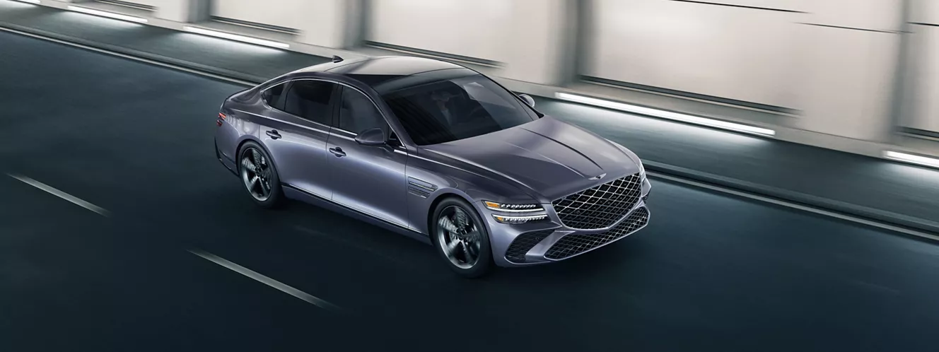 High 3/4 front passenger side view of Genesis G80 in Ceres Blue driving through tunnel