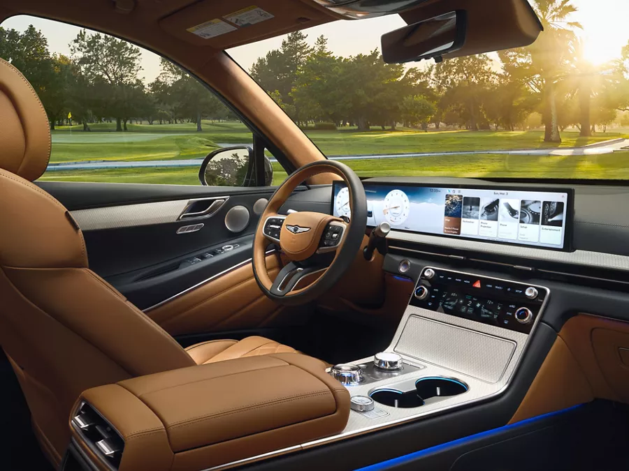 Interior view from passenger side of Genesis GV80 looking out to a sunny golf course