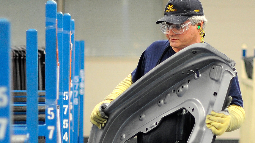 Daryl, empleado de Hyundai, sostiene la parte de un automóvil en la planta de fabricación automotriz de Hyundai en Montgomery, Alabama