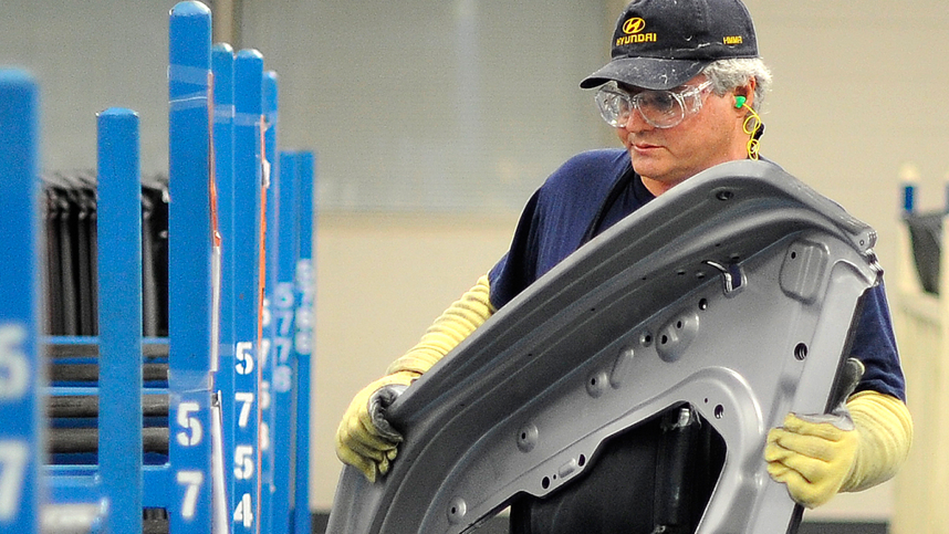 Auto worker carrying a panel