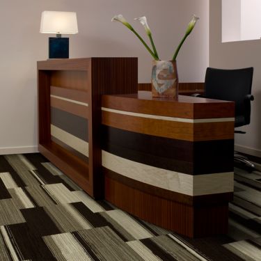 Interface Across the Board carpet tile in reception area with wood desk and Calla lillies imagen número 1