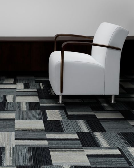 Interface Across the Board carpet tile in seating area with white chair
