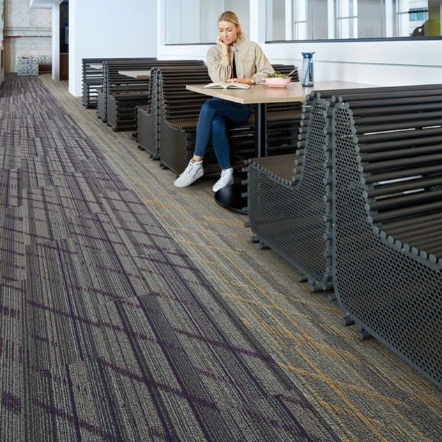 Interface Luminescent plank carpet tile in cafe area with woman seated at table