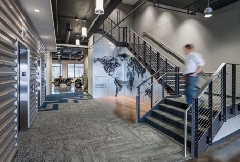 Interface HN810, HN820, HN840 and HN850 plank carpet tiles in open stairwell with four wheelers in background at Polaris Industries image number 7