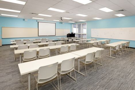 Interface Grooved carpet tile in training room with rows of white tables and chairs