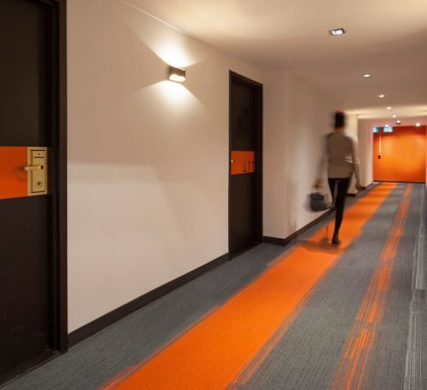 Interface Off Line plank carpet tile in long corridor with woman walking