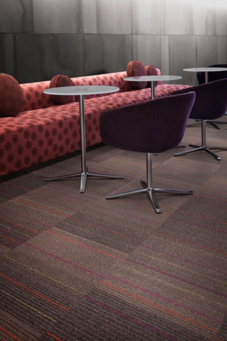Interface 2nd Avenue carpet tile in lounge with long pink sofa, round tables and purple chairs image number 5