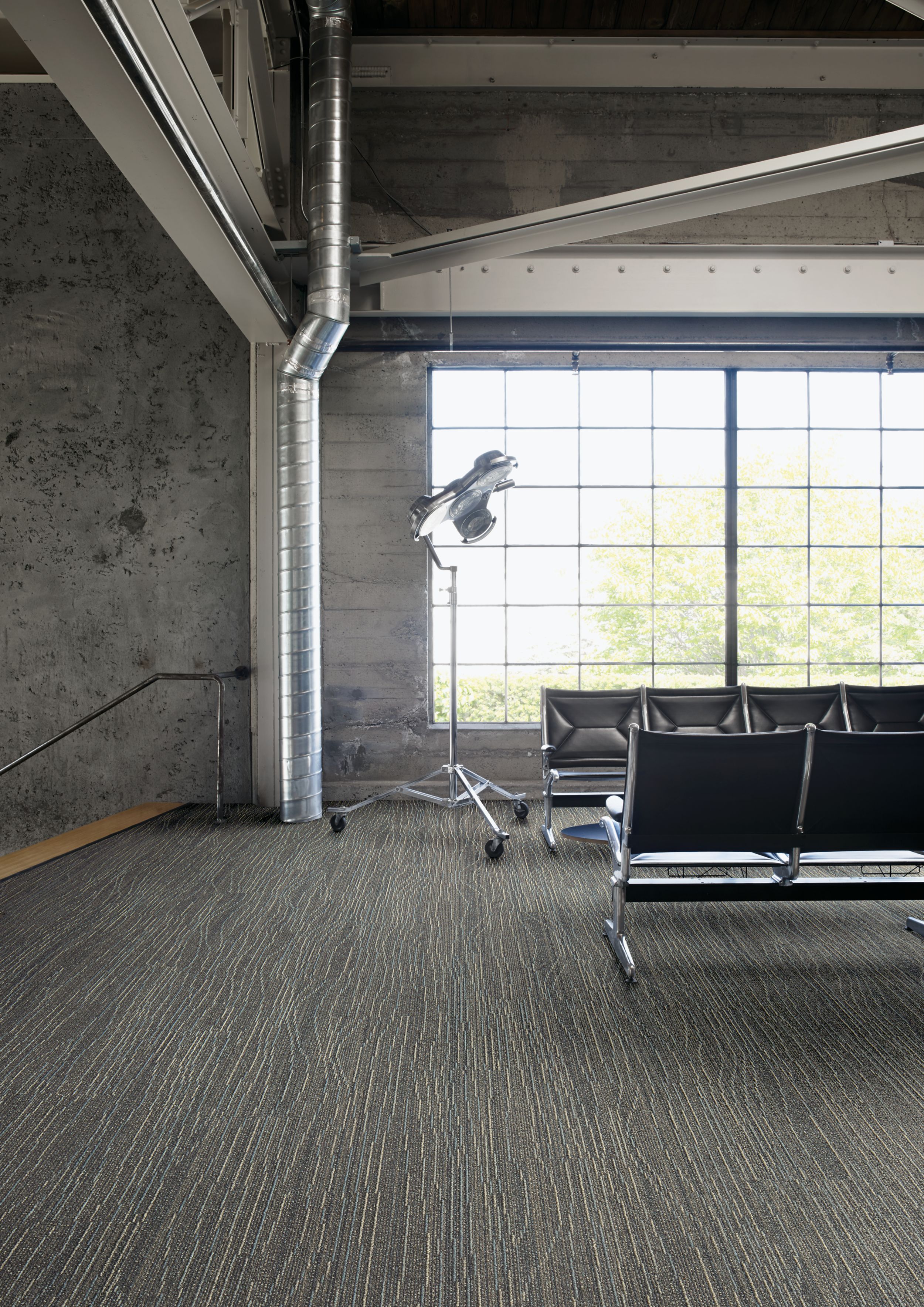 Interface Snow Moon plank carpet tile in waiting area with concrete walls and exposed beams imagen número 2