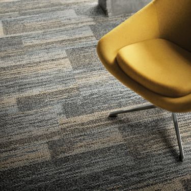 Close-up of Interface AE313 plank carpet tile with yellow chair imagen número 1