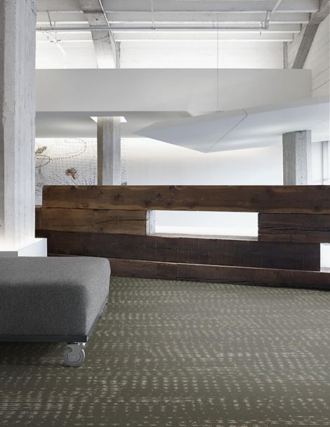 Interface Aquatint plank carpet tile in lobby with gray ottoman and wood desk