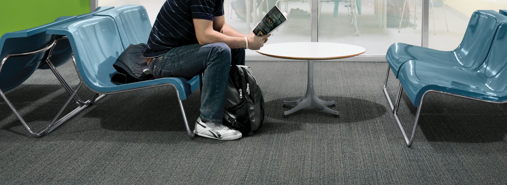 Interface BP410 plank carpet tile with student seated on bench in front of meeting area