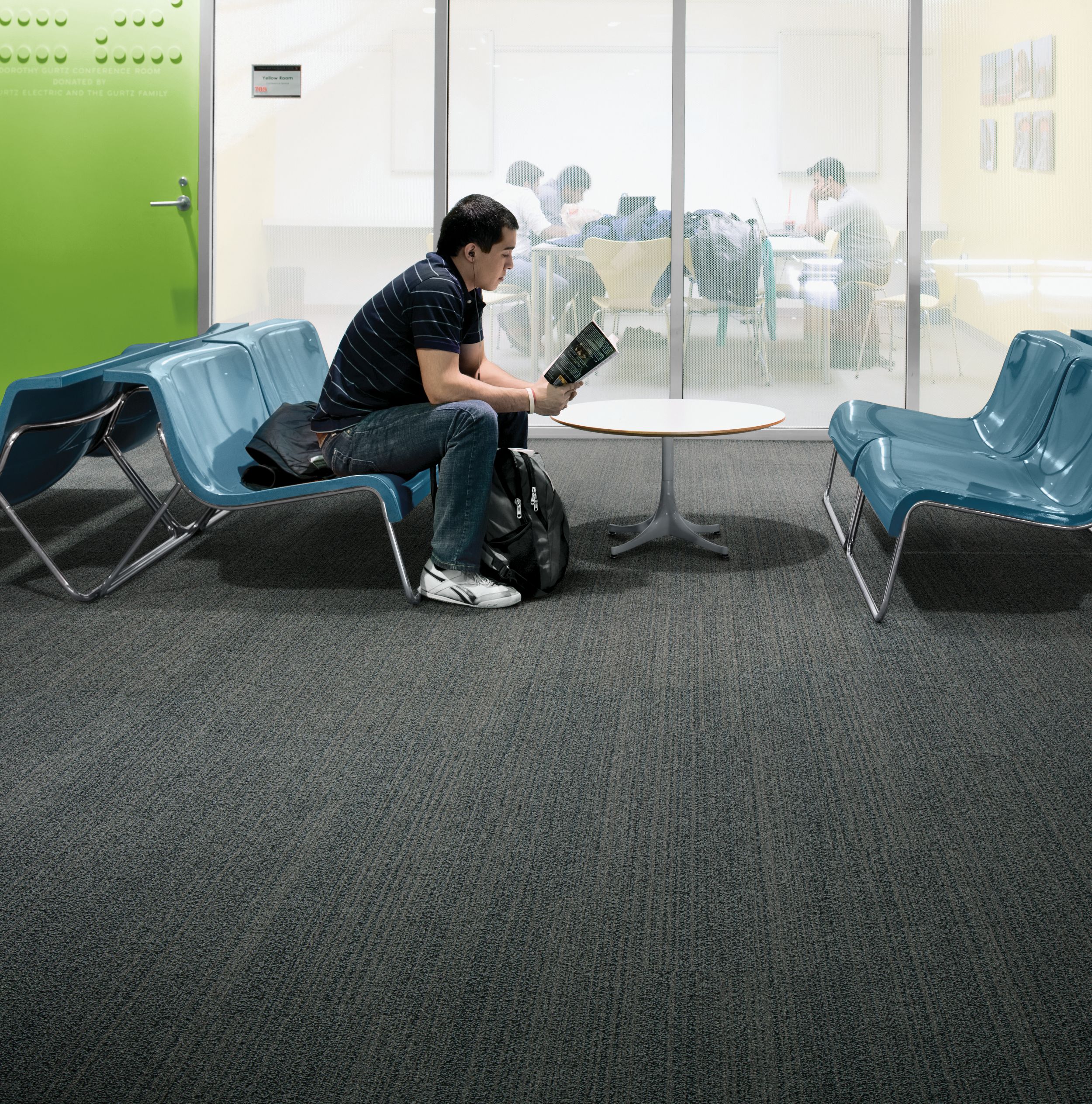 Interface BP410 plank carpet tile with student seated on bench in front of meeting area image number 7