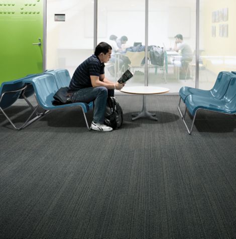Interface BP410 plank carpet tile with student seated on bench in front of meeting area imagen número 3