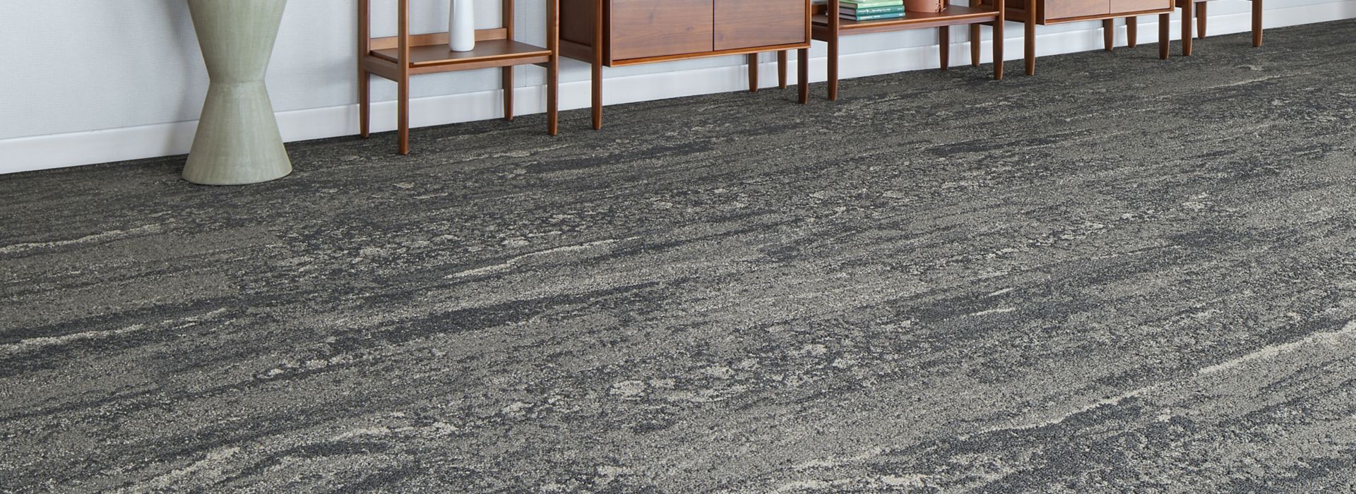 Interface Ferris plank carpet tile in lobby area with bookcases and large plant