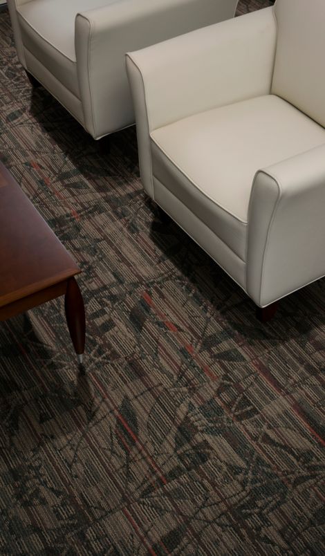 Interface Broadleaf carpet tile in seating area with two cream chairs and wood table
