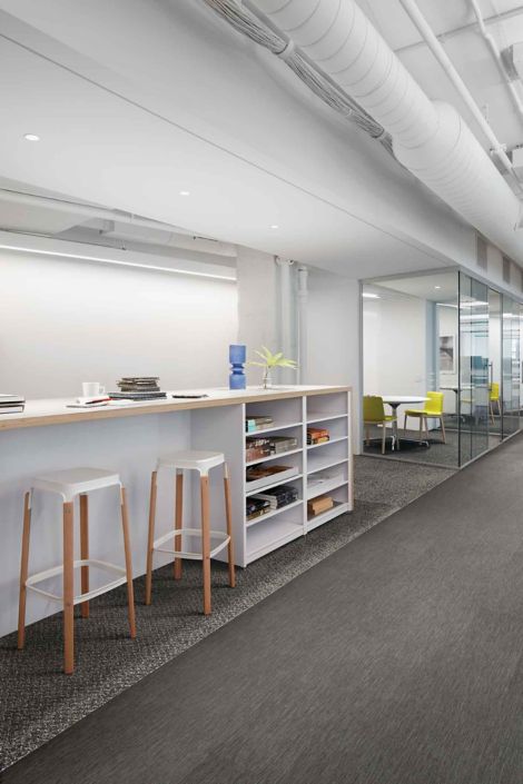 Interface Reade Street carpet tile with Brushed Lines LVT in office corridor with high table, stools and a series of small meeting rooms image number 3