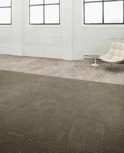 Interface CT101 carpet tile and Textured Stones LVT in open area with concrete walls and chair image number 5