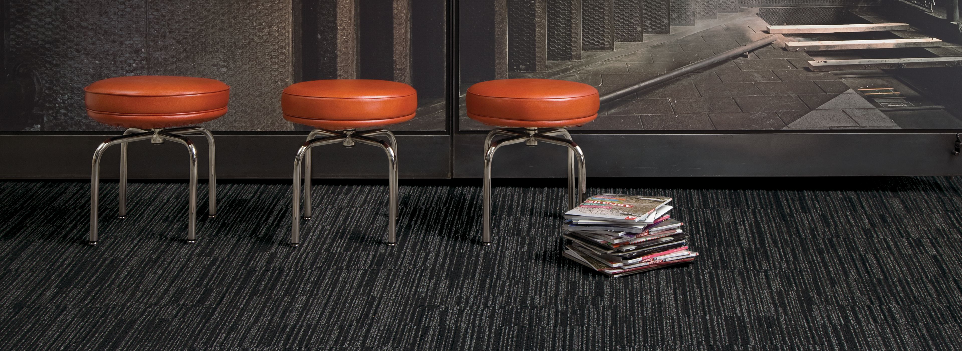 Interface CT102 carpet tile in open area with three red stools and stack of books image number 1