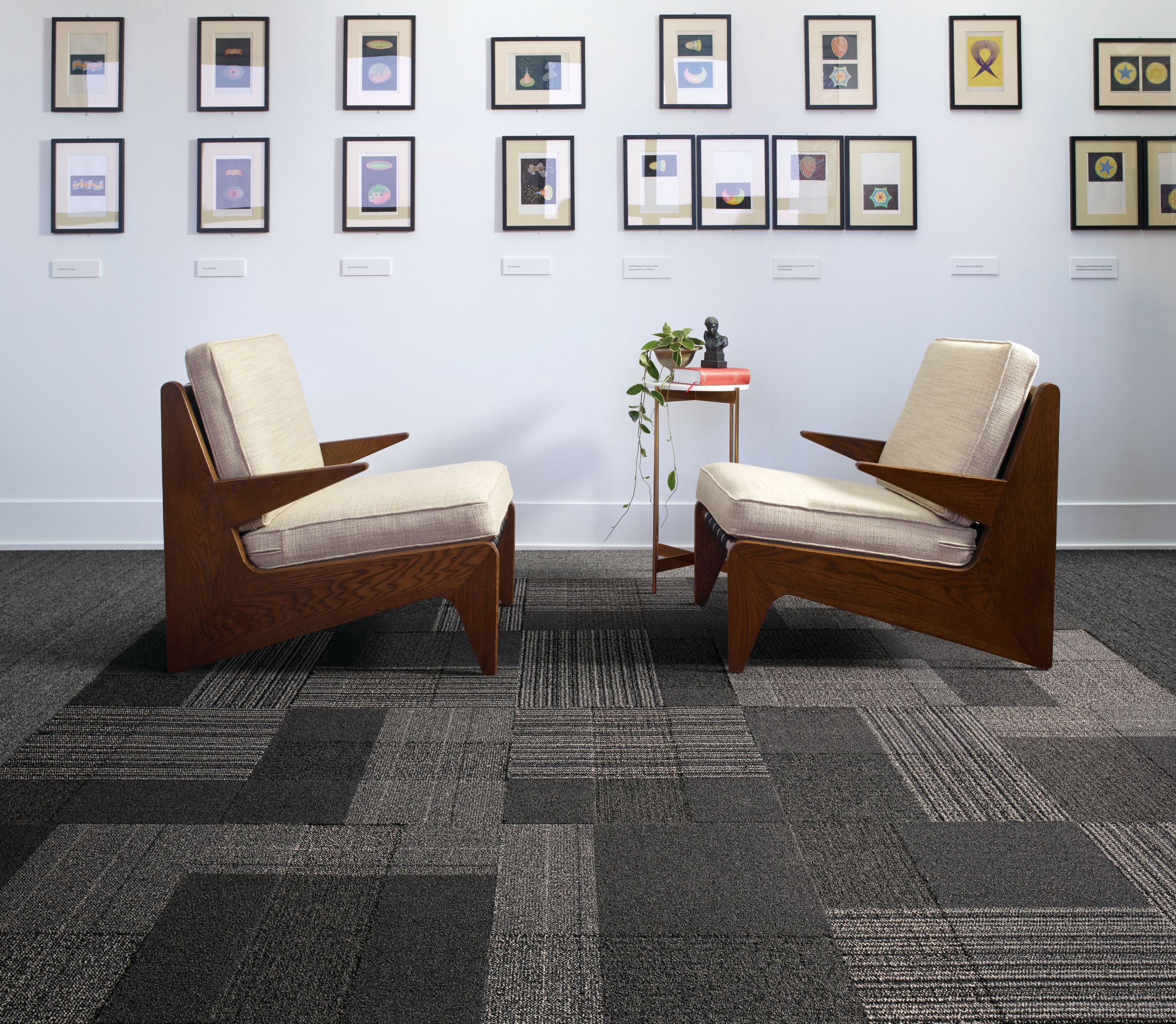 Interface ShadowBox Velour carpet tile and WW860 plank carpet tile in seating area with two chairs and a lot of small prints on the wall image number 5