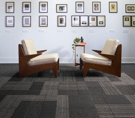 Interface ShadowBox Velour carpet tile and WW860 plank carpet tile in seating area with two chairs and a lot of small prints on the wall image number 5