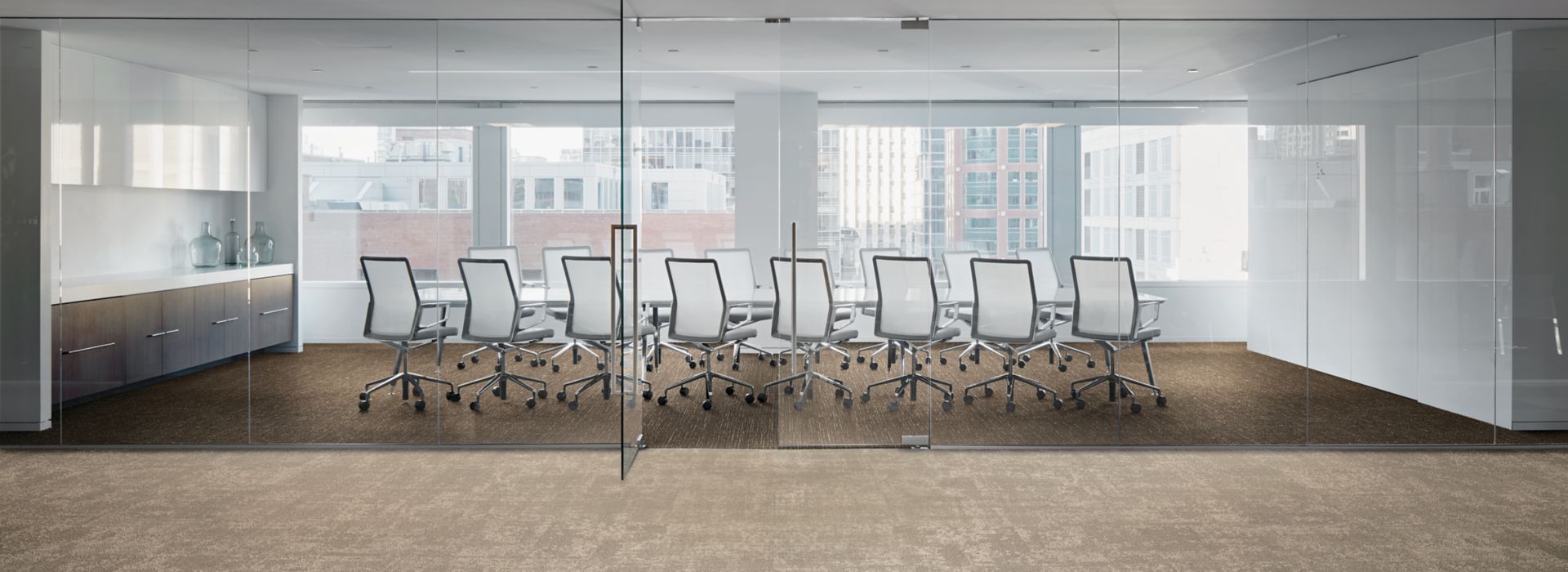 Interface Cloud Cover and Night Flight carpet tile in office with glass-enclosed meetinig room