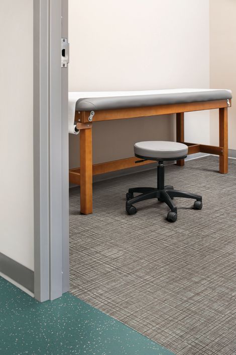 Interface Criterion Classic Wovens LVT and noraplan enironcare rubber flooring in patient room with table and rolling stool afbeeldingnummer 4