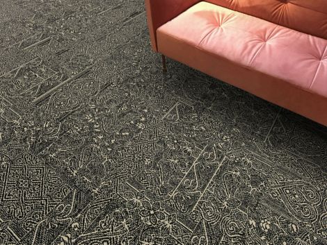 Detail of Interface DL924 carpet tile with salmon colored sofa