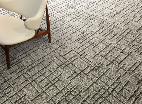 Detail of Interface DL925 carpet tile with cream colored chair imagen número 2