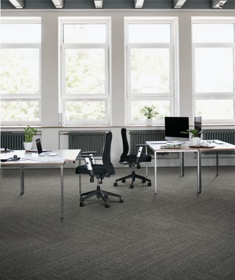 Interface Drawn Thread plank carpet tile in open work area with two desks and chairs