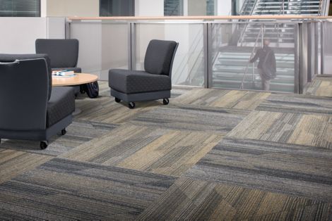 Interface Driftwood plank carpet tile in seating area with three chairs surrounding a table