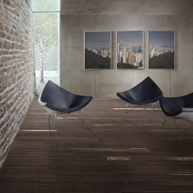 Interface Duo and Trio plank carpet tile in seating area with three chairs and paintings on wall