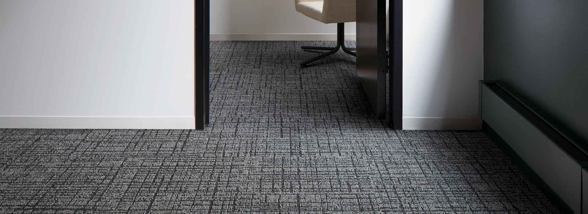 Interface Duplex carpet tile in small room with doorway leading to other room