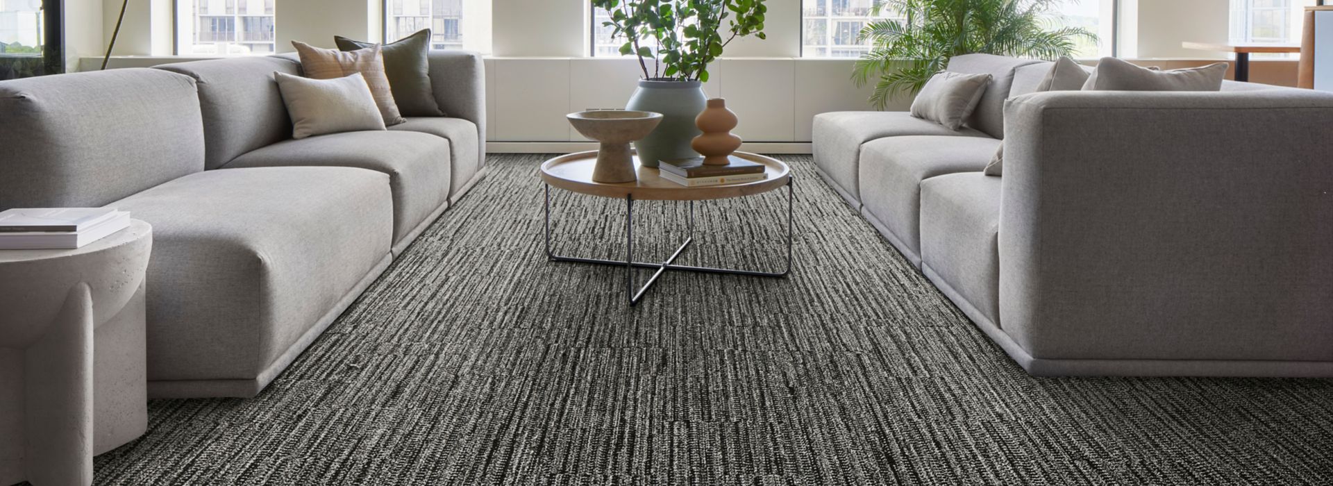 Interface EE714 plank carpet tile in lobby with grey sofas and natural light