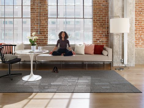 Interface EM551 plank carpet tile with woman meditating on couch