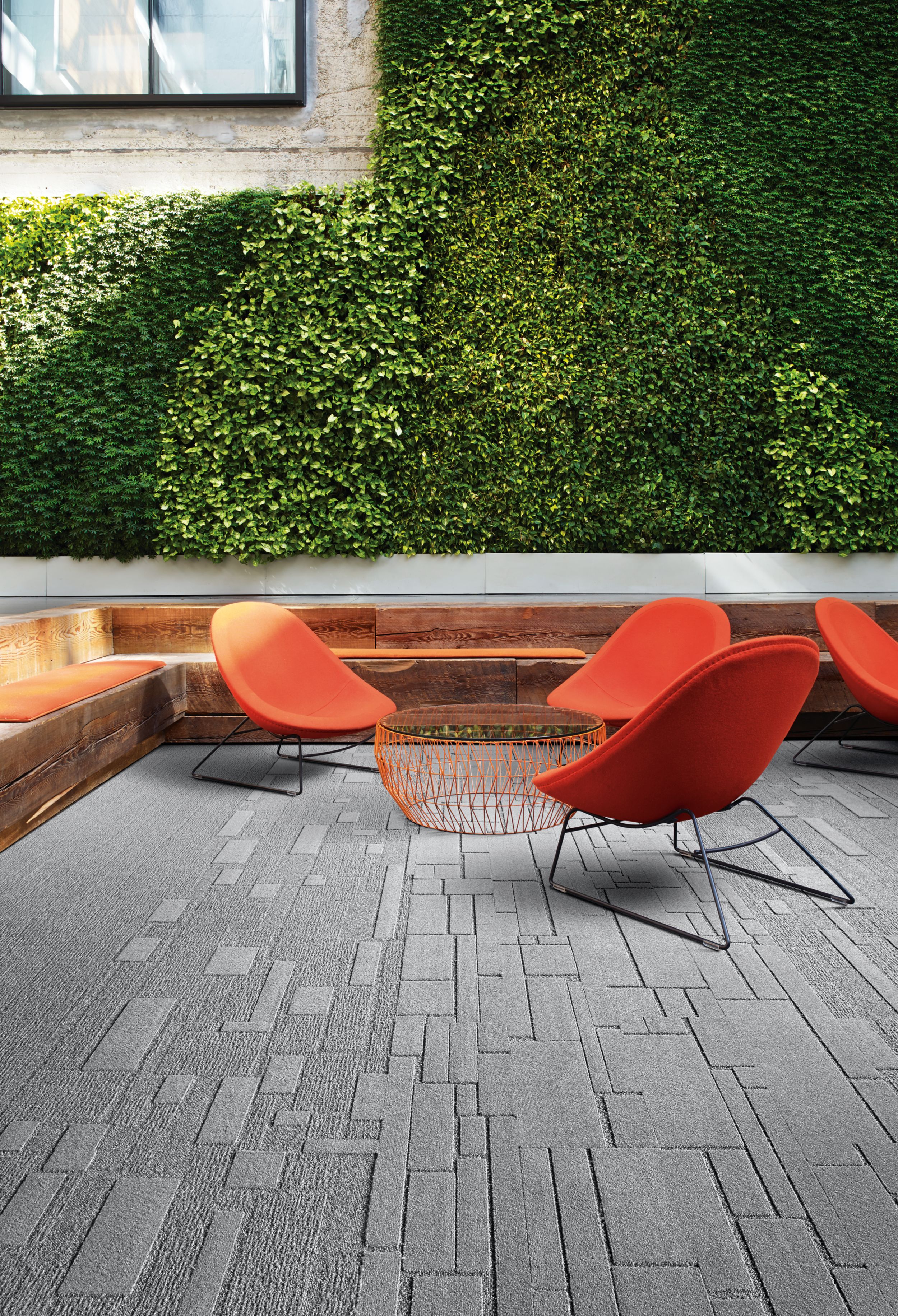 Interface EM551, EM552 and EM553 plank carpet tiles in outdoor green space with orange chairs image number 12