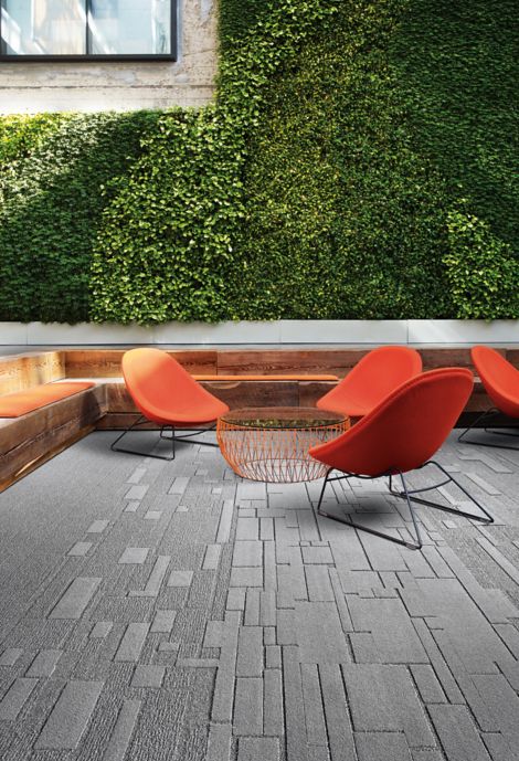 Interface EM551, EM552 and EM553 plank carpet tiles in outdoor green space with orange chairs