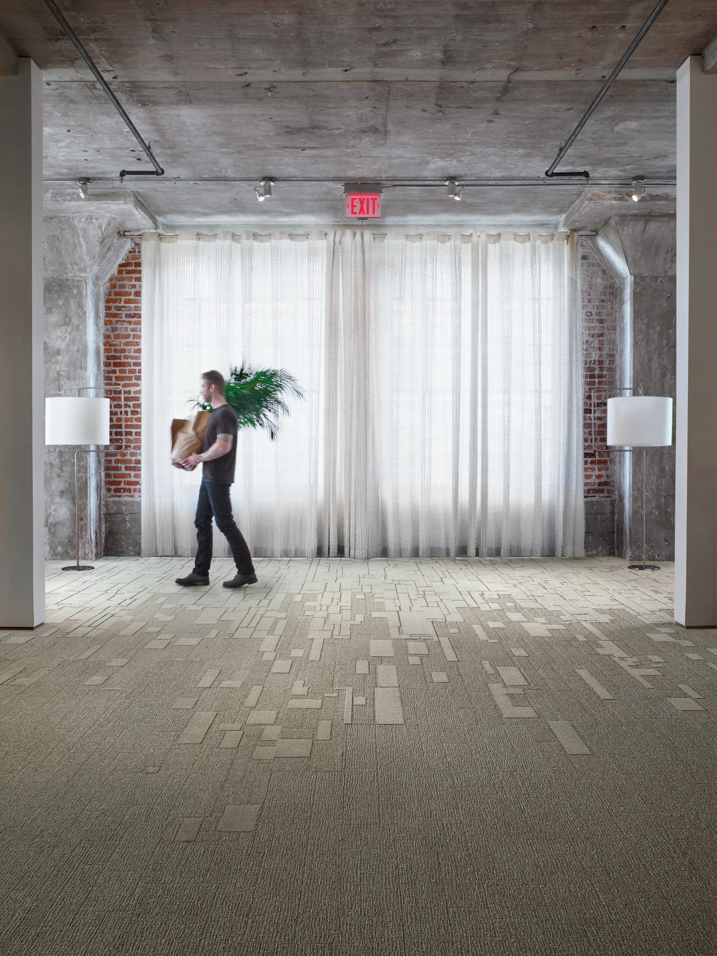 Interface EM551 and EM553 plank carpet tile in open office with man carrying a plant imagen número 9