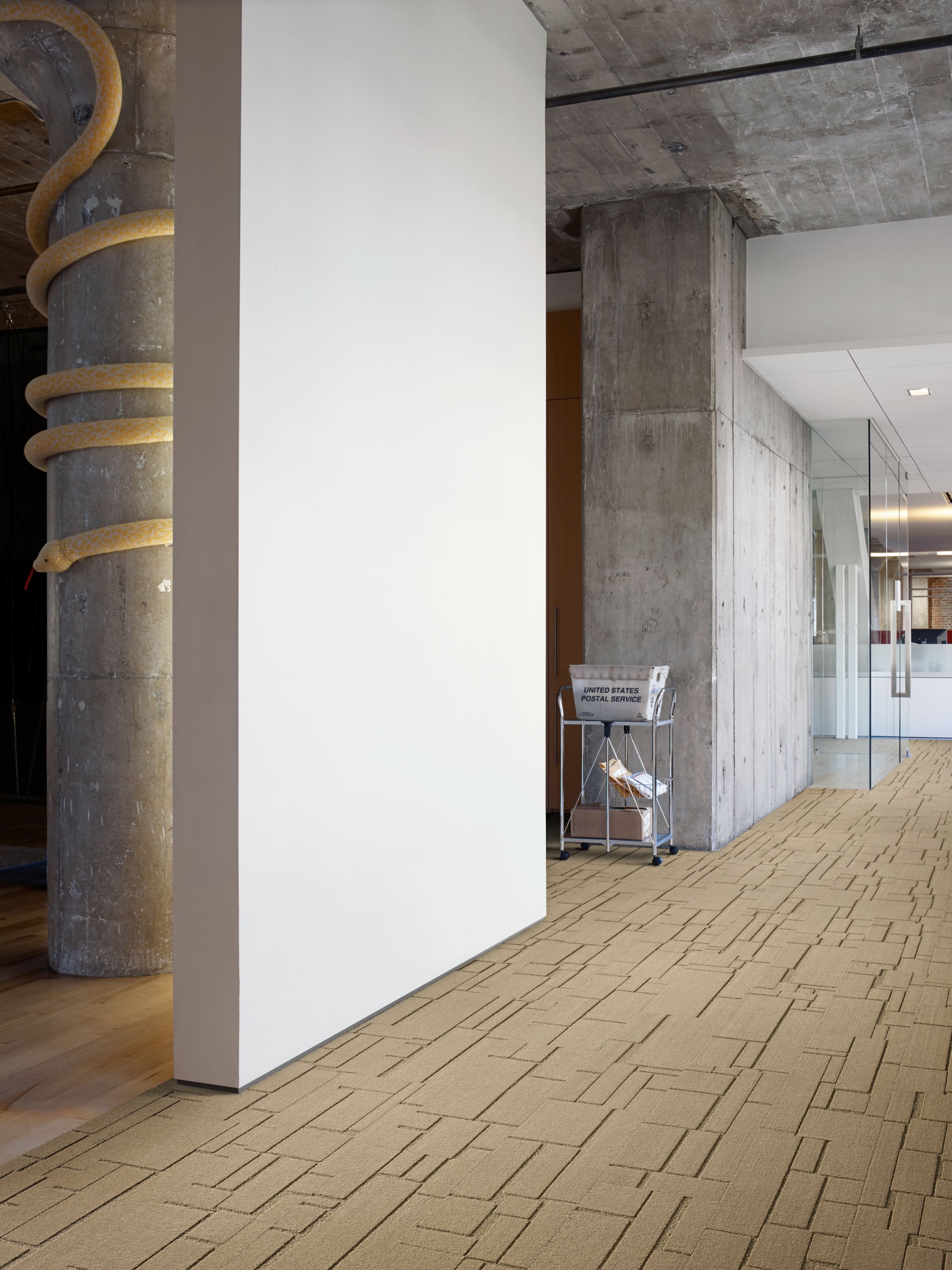 Interface EM553 plank carpet tile in entryway with cement column with snake wrapping around image number 6
