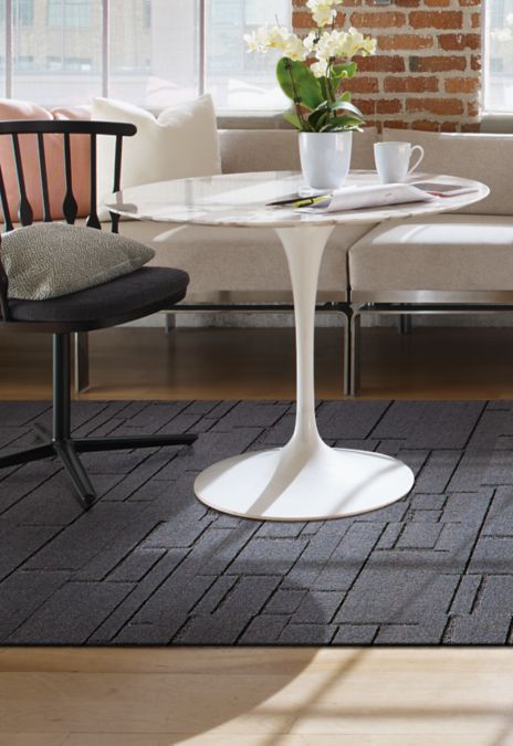 Interface EM553 plank carpet tile with chair and table with white orchid