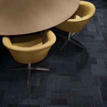 Interface Entropy carpet tile in meeting room with round wooden table and yellow chairs