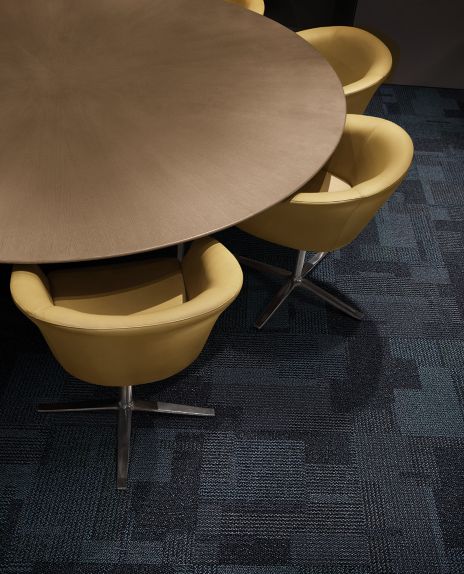 Interface Entropy carpet tile in meeting room with round wooden table and yellow chairs