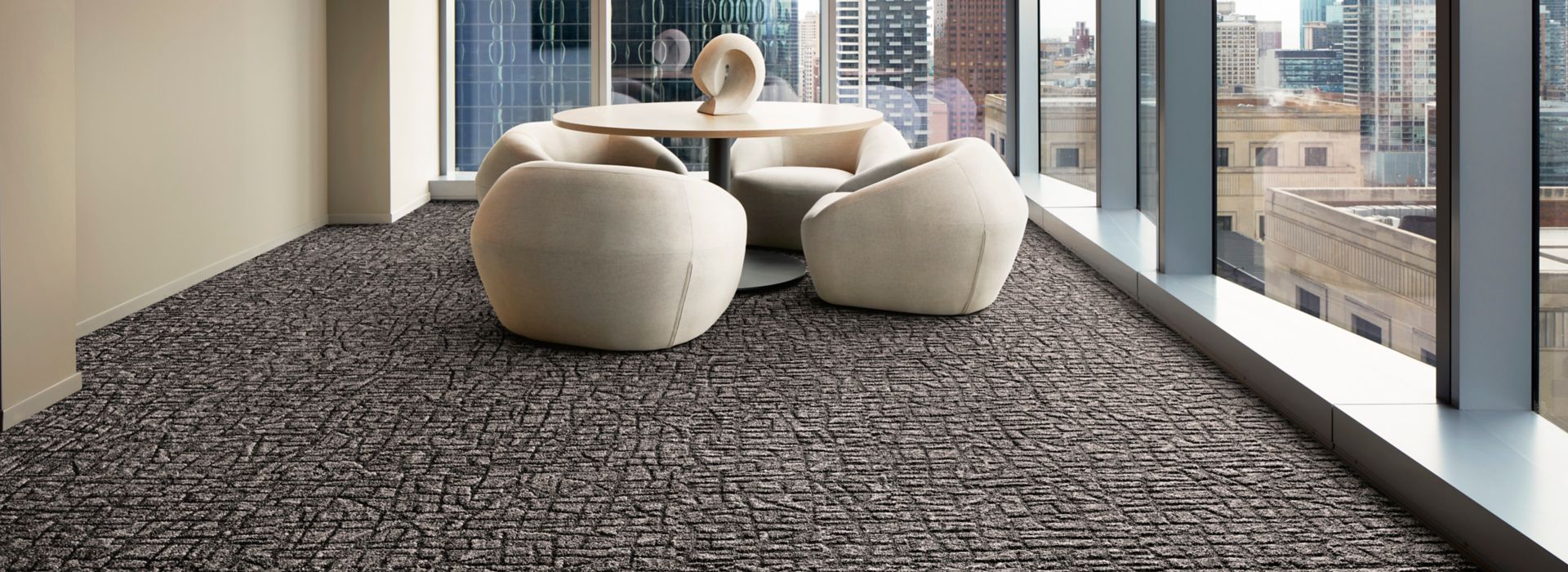 Interface E610 carpet tile in modern office meeting area with small table and low chairs