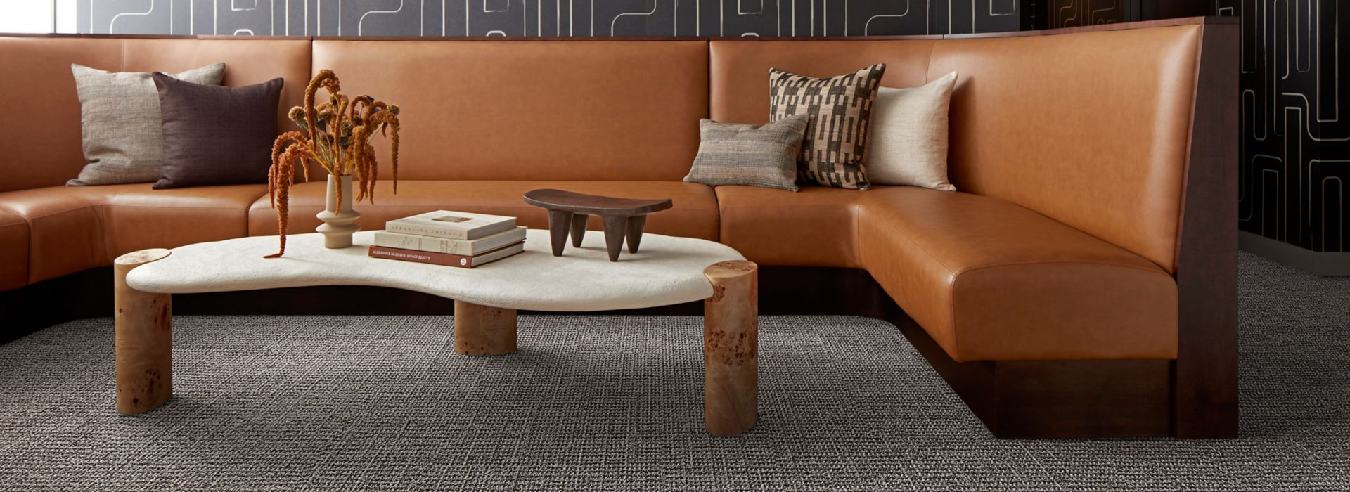 Interface E613 plank carpet tile in corporate lobby with brown wraparound sofa and stone coffee table