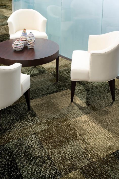 Interface Exposed carpet tile in meeting area with wooden table and white chairs with frosted glass room in background